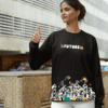 Woman in black “Future” graphic sweatshirt showing thumbs up outdoors