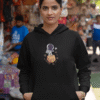 Woman wearing a black astronaut graphic hoodie standing in a colorful street market