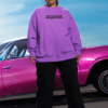 Model wearing a purple oversized resilience sweatshirt styled outdoors with a vintage car.