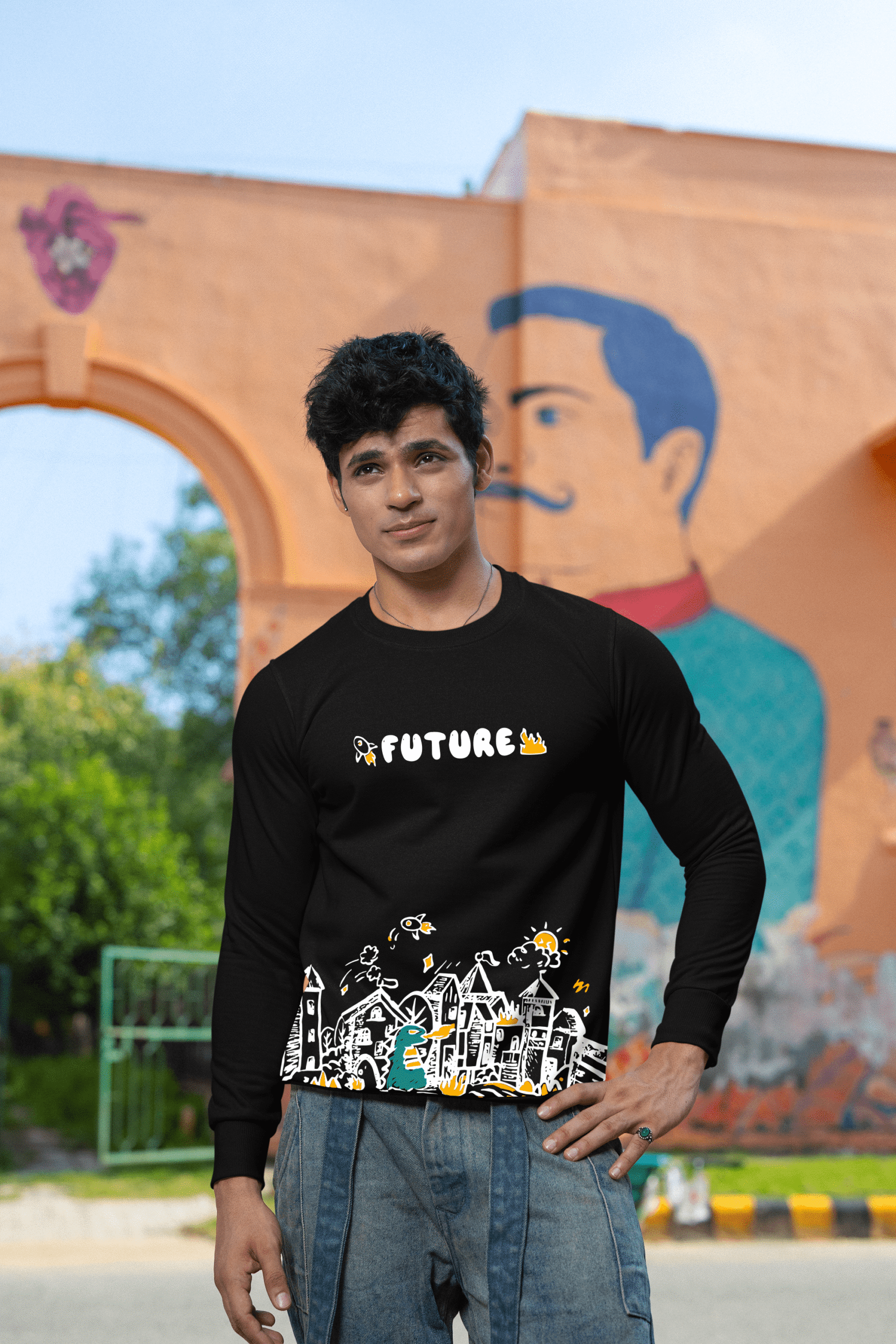 Man wearing black “Future” graphic sweatshirt posing outdoors with a mural background