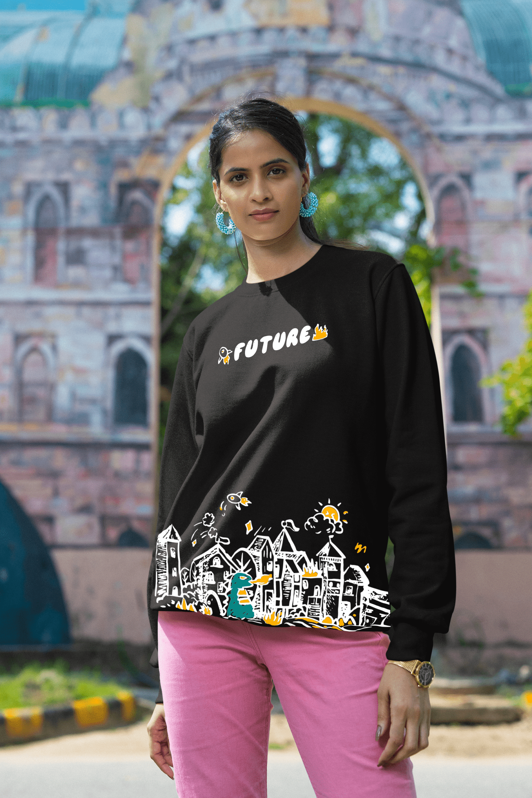 Woman in black “Future” graphic sweatshirt posing outdoors near architectural backdrop