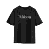 Black oversized T-shirt with a bold white handwritten-style logo on the chest that reads “TRAVI$ SCOTT.”