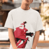 Man wearing white oversized T-shirt with bold red abstract face print while posing outdoors in a relaxed streetwear look.