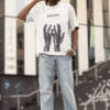 Man wearing a white “BREATHE” graphic T-shirt with abstract blue hand artwork, posing outdoors in relaxed streetwear.