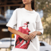 Woman wearing a white oversized T-shirt with a bold red artistic face graphic while posing outdoors in an urban setting.