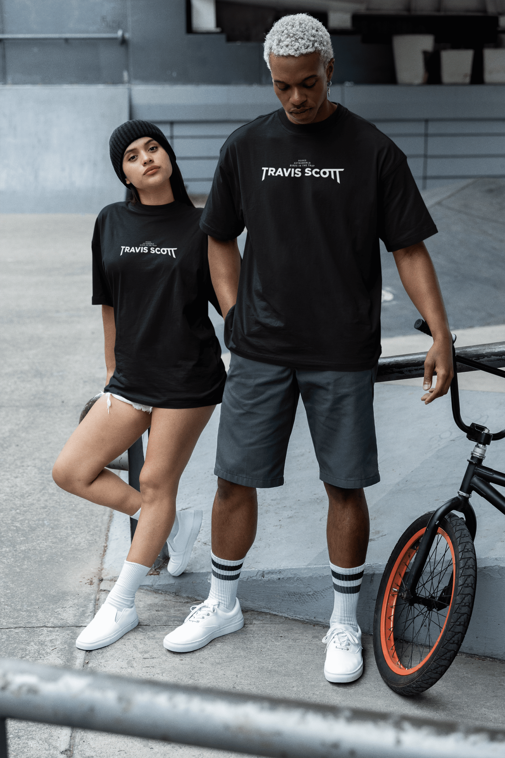 Two people wearing black Travis Scott–themed graphic T-shirts while standing outdoors.