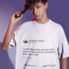 Teenage boy wearing an oversized white Kanye West tweet T-shirt while holding a gaming controller against a purple background.