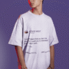 Man wearing an oversized white T-shirt with a Kanye West tweet graphic printed on the front, standing against a purple background.