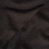 Close-up view of black cotton fleece fabric showing smooth outer surface and soft brushed interior.