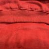 Close-up texture of red cotton fleece fabric with ribbed stitching.